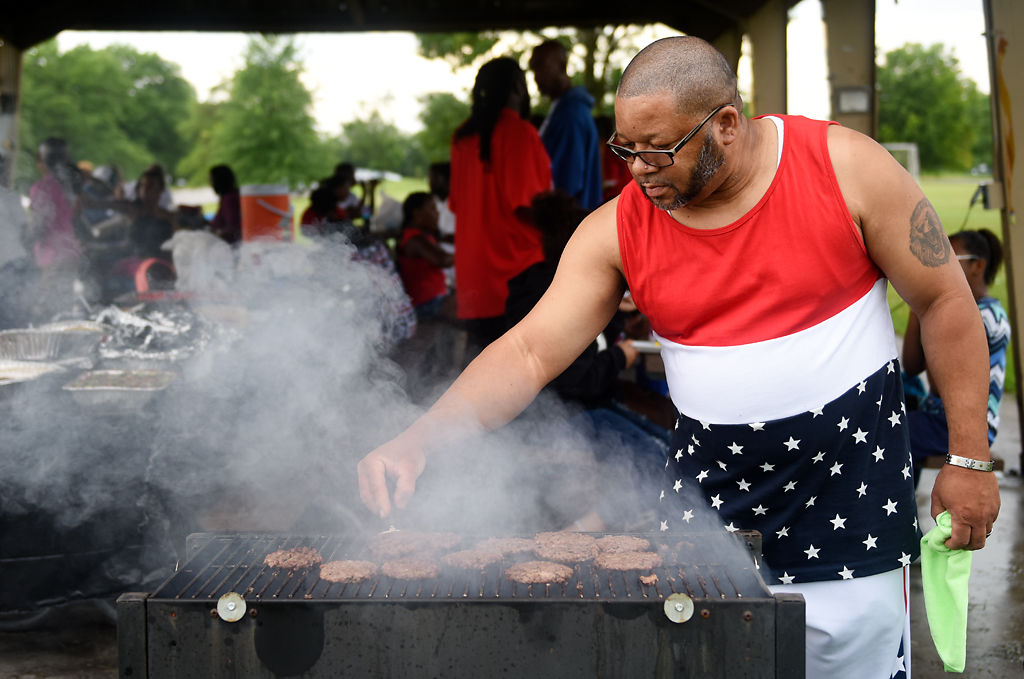 Ronald Sanders flips burgers on one of the three grills running the Hall family reunion
